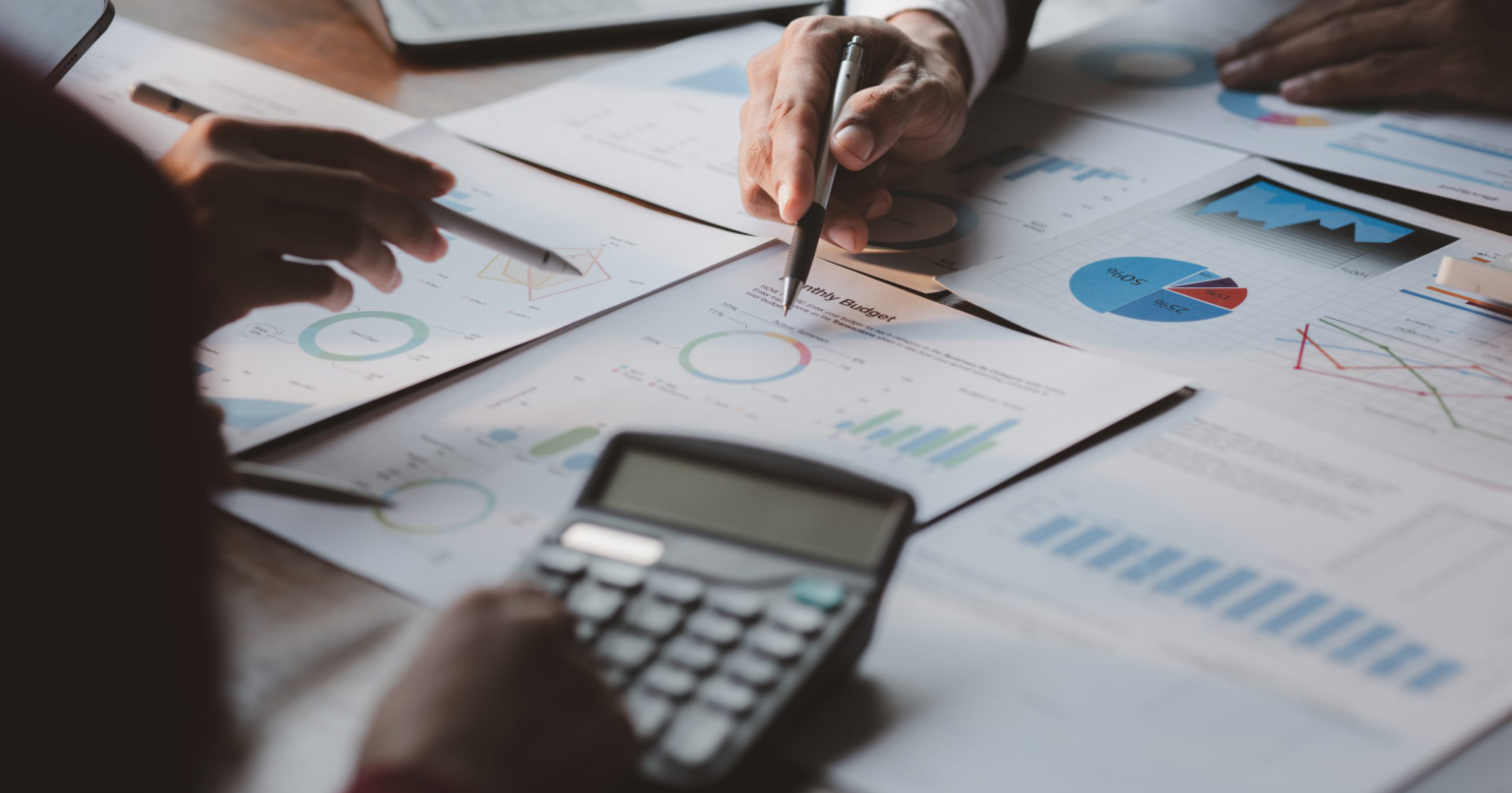 a group of business people working over a monthly budget with the help of calculators