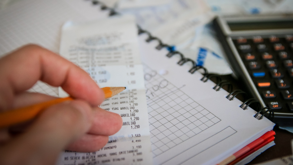 a person calculating totals from a receipt