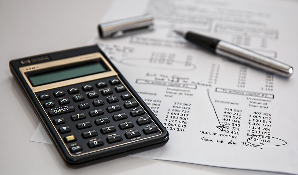 a calculator on top of an investment sheet